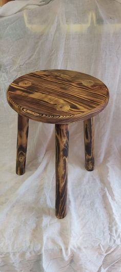 a wooden table sitting on top of a white sheet