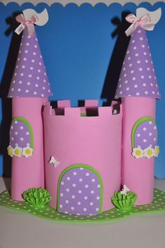 a pink castle made out of paper with polka dots on the top and two towers