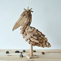 a bird made out of wood sitting on top of a wooden table