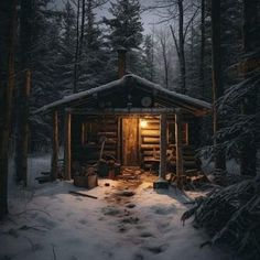 a cabin in the woods with snow on the ground and lights shining from it's windows