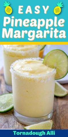 two glasses filled with pineapple margarita on top of a wooden table next to lime slices