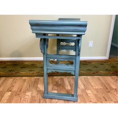 a small blue table with drawers on it