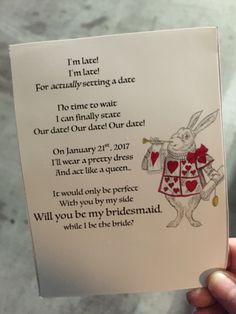 a person holding up a card with an image of a rabbit in a red dress