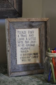 a wooden frame with writing on it next to a jar of pencils and markers