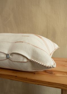 a white pillow sitting on top of a wooden table