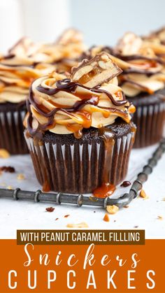 two cupcakes with peanut caramel filling on top and the words, snickkers cupcakes