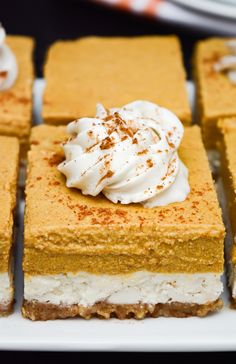 several squares of pumpkin cheesecake with whipped cream on top