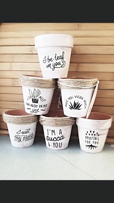 six white buckets with i'm not dead written on them are stacked in front of a wooden wall