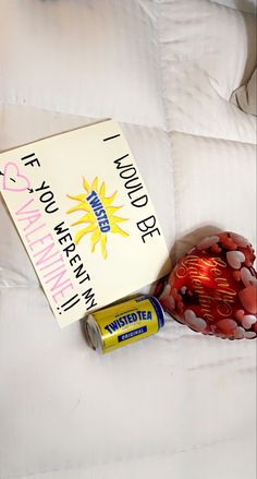 a book and some candy are laying on a white bed with a sign that says, i love you very much