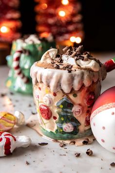 there is a cup with some frosting on it next to christmas decorations and candy canes