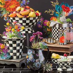 there are many vases with flowers and fruit in them