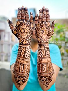 a woman holding her hands up with henna on it