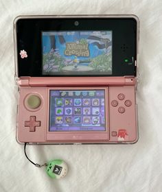 a pink nintendo wii game system sitting on top of a white sheet with a mouse attached to it