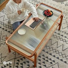 a person sitting at a table with a laptop and coffee cup in front of them