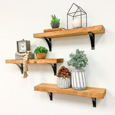 two wooden shelves with pots and plants on them