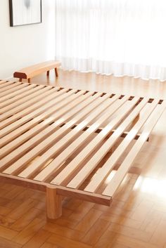 a bed with wooden slats on top of it in a room next to a window