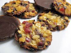 four cookies with chocolate and fruit toppings on a white plate