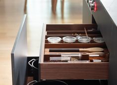 an open drawer in a kitchen filled with spices