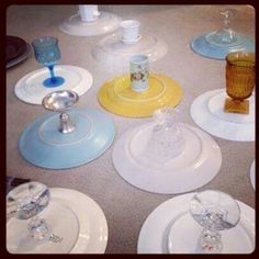 there are many different colored glass plates on the table together, and one is empty