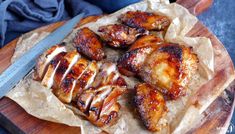 some chicken wings are on a cutting board with a knife