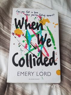 the book when we collided by emery lord is laying on a bed with white sheets