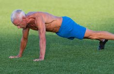 an older man is doing push ups on the grass