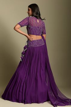 Purple georgette lehenga with pleated flare and embroidered waistband. Paired with illusion boat neck blouse with all over sequin, cut dana, crystal work and dupatta with scattered details.
Component: 3
Pattern: Embroidered
Type Of Work: Sequin, Crystals and Cut Dana Work
Neckline: Illusion Boat Neck
Sleeve Type: Half Sleeves
Fabric: Georgette
Color: Purple
Other Details: 
Broad waistband
Embroidered border on dupatta
Tasselled edges on dupatta
Closure:
Lehenga: Side tasselled tie-up
Blouse: Bac Elegant Georgette Skirt Set For Reception, Elegant Floor-length Georgette Skirt Set, Formal Fitted Georgette Lehenga, Semi-stitched Georgette Skirt Set For Reception, Fitted Georgette Saree Skirt Set, Fitted Georgette Skirt Set With Zari Work, Formal Georgette Choli For Navratri, Fitted Georgette Skirt Set For Navratri, Formal Fitted Georgette Sharara