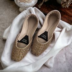 Introducing our Handmade Bridal Khussa with Crystal Embellishments - the epitome of elegance and comfort for your special day. 🌟 Embrace the Charm: Crafted with love and attention to detail, our bridal Khussa shoes are a perfect fusion of tradition and modern aesthetics. The delicate crystal embellishments add a touch of sparkle that will make you shine on your wedding day. 👑 Regal Comfort: We understand that every bride deserves to feel like royalty. That's why our Khussa shoes come with doub Traditional Gold Flats For Party, Wedding Flats With Gota Work, Gold Embellished Heels For Reception, Flat Heel Wedding Shoes With Gota Work, Elegant Gold Embellished Flats, Embellished Flat Heel Wedding Shoes For Reception, Elegant Embellished Gold Flats, Elegant Festive Flats With Mirror Work, Elegant Flats With Mirror Work For Festive Season