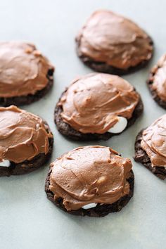 chocolate cookies with frosting and marshmallows arranged on a baking sheet, ready to be eaten