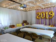 a room with tables, chairs and balloons in the shape of letters that read 2009