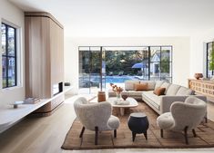 a living room filled with furniture and large windows