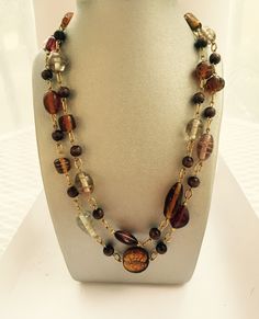 This necklace brings warmth to any look. It can be worn as a single long necklace or a wrap it around as it is a 40" long necklace.  It features acrylic, wood and glass beads. Adjustable Brown Glass Necklace, Brown Glass Necklace For Gift, Glass Beaded Chain Long Necklace, Handmade Brown Necklaces For Layering, Adjustable Brown Multi-strand Long Necklace, Handmade Brown Glass Necklaces, Adjustable Multi-strand Brown Long Necklace, Brown Glass Beaded Chain Necklace, Elegant Brown Glass Necklace