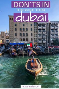 a boat floating on top of a body of water next to a tall building with the words don't's in dubai