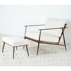 a white chair and footstool sitting on top of a rug