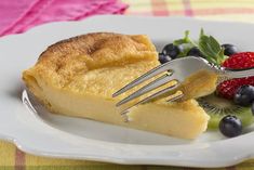 a piece of pie on a plate with berries and a fork