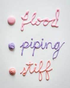 the words flood piping stuff are spelled with pink and purple icing on a white surface