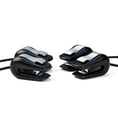 three pieces of black plastic sitting next to each other on a white surface with wires