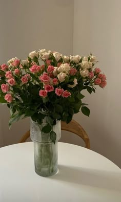 a vase filled with pink and white flowers on top of a table