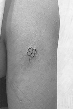 a small four leaf clover tattoo on the left arm