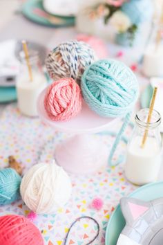 balls of yarn are sitting on a table with other crochet items and utensils