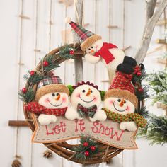 three snowmen are hanging from a wreath