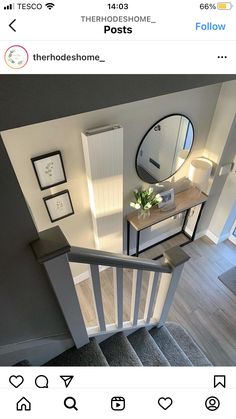 an aerial view of a staircase with pictures on the wall and stairs leading up to it