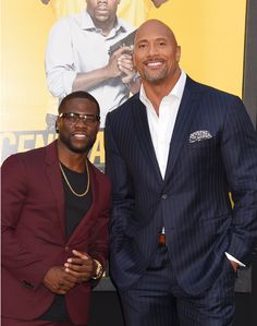 two men standing next to each other in front of a movie poster at the same time