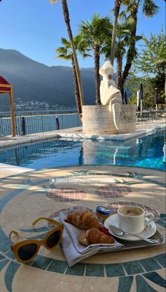 coffee and croissants on the edge of a swimming pool