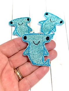 someone is holding out their handmade brooch with two little blue bears on it