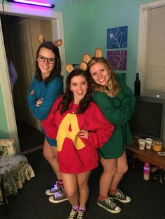 three girls dressed in costumes posing for the camera