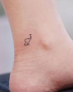 an elephant tattoo on the foot of a woman's left ankle is shown in black ink