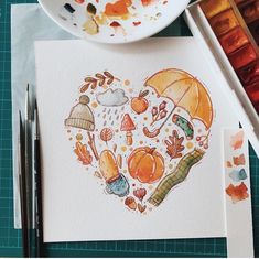 a heart shaped painting with autumn items on it