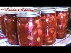 several jars filled with pickles sitting on top of a table