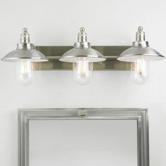 three light bathroom vanity fixture with two bulbs on each side and a mirror behind it